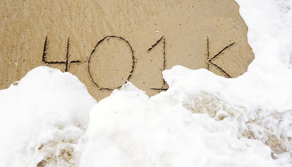 401k escrito en la arena de una playa muy cerca a una ola de agua que lo va a cubrir