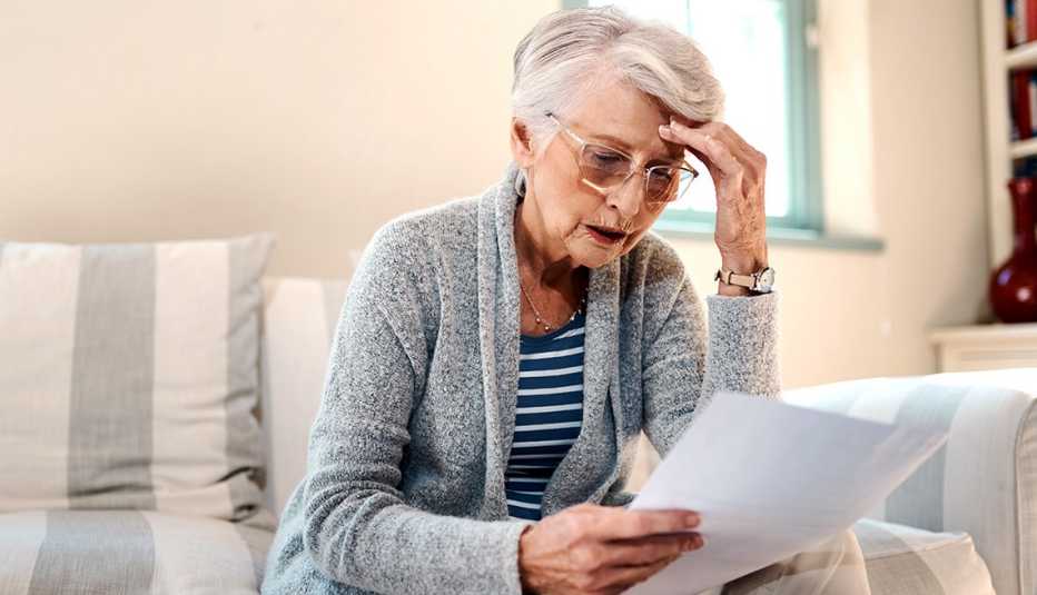 Mujer mayor con preocupación al mirar un análisis que sostiene en la mano.