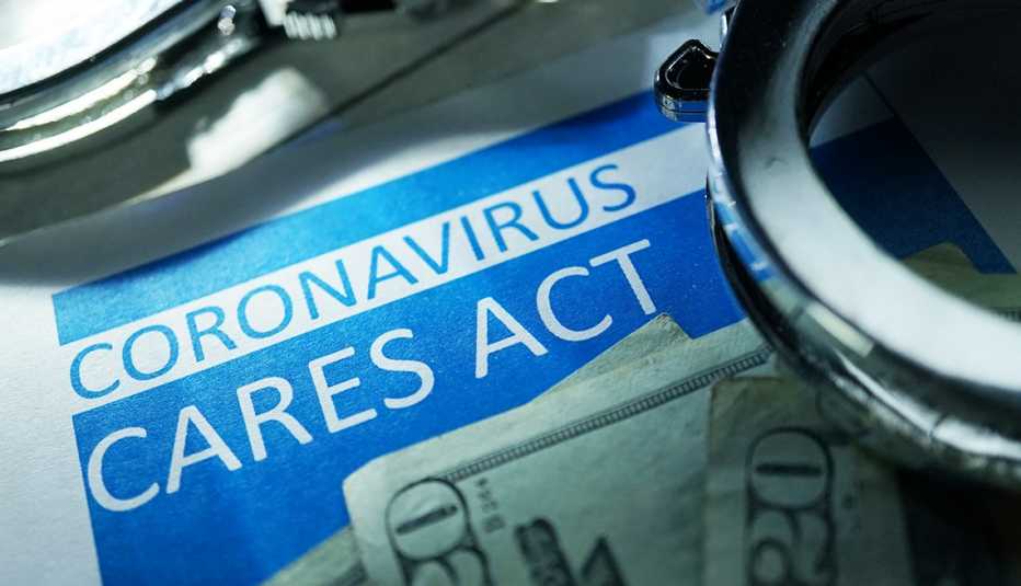 Palabras Ley Cares del coronavirus al lado de un billete de $20 dólares y unas esposas al lado.