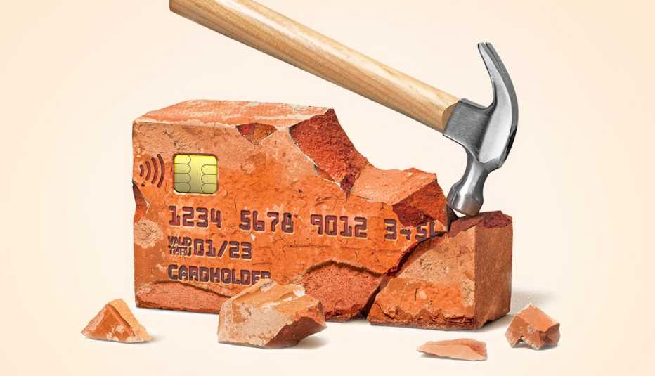 Ladrillo en forma de tarjeta de crédito y un martillo que lo rompe
