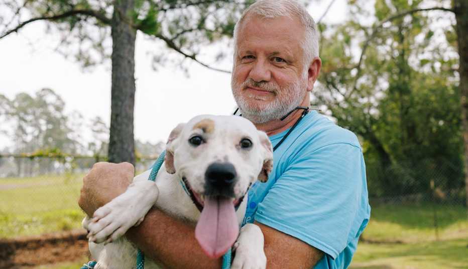 Michael Merrill sosteniendo una perra adoptiva llamada Maggie