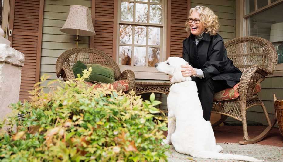 Mujer sentada frente a su casa con su perro