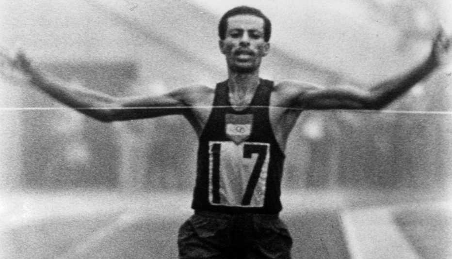 Abebe Bikila cruza la línea de meta para ganar la medalla de oro en el maratón masculino e imponer un récord en los Juegos Olímpicos de verano de 1964.
