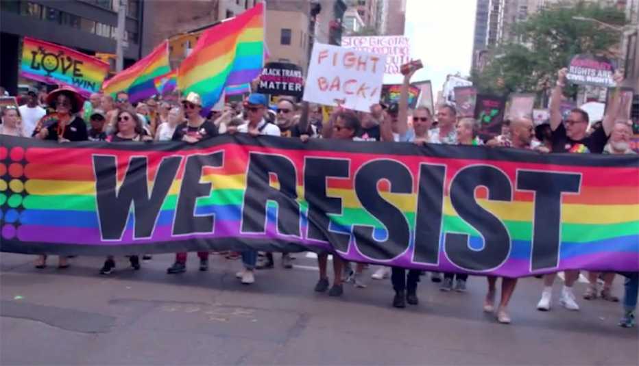 Una multitud en una manifestación LGBTQ sosteniendo un cartel que dice "Resistimos".