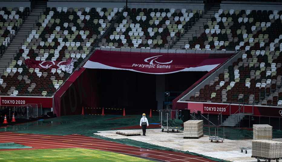 Un miembro del personal pasa junto a la pancarta de los Juegos Paralímpicos de Tokio en el Estadio Olímpico.