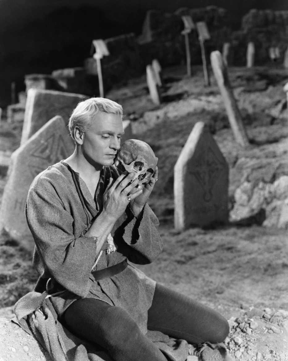 Laurence Olivier sostiene una calavera en un cementerio en una escena de la película "Hamlet".