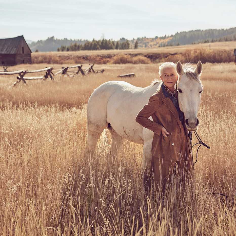 Helen Mirren posa junto a un caballo blanco en un campo de Montana