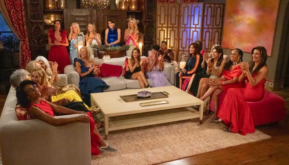 the women contestants of the golden bachelor sitting together on the couches inside the mansion
