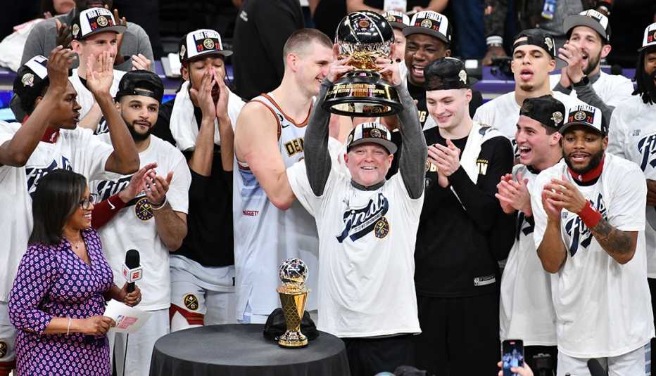 Michael Malone, entrenador principal de los Denver Nuggets levanta en sus manos un trofeo.