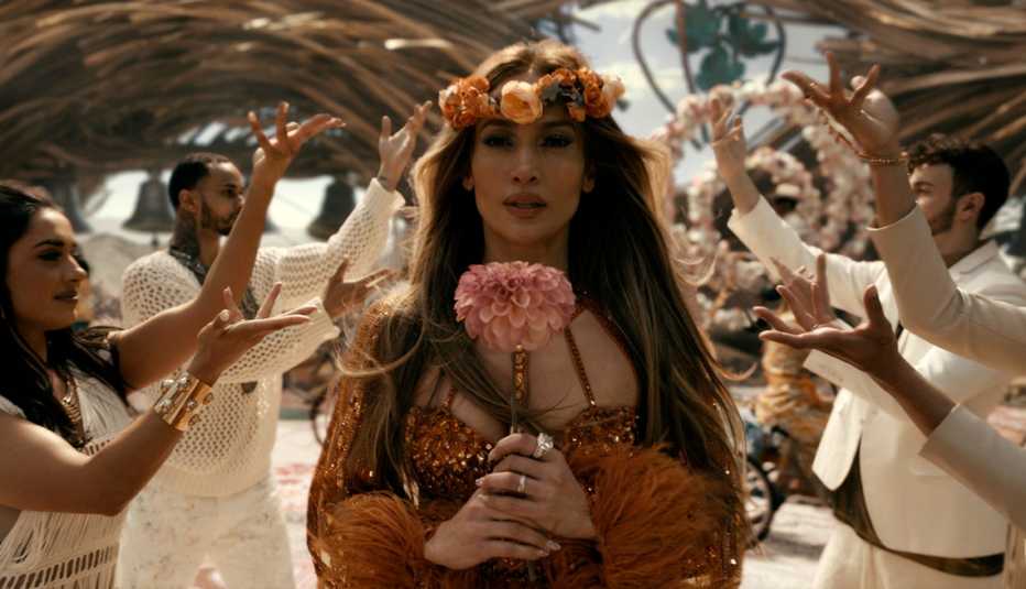 Jennifer Lopez sostiene una flor en una escena de "This Is Me ... Now".