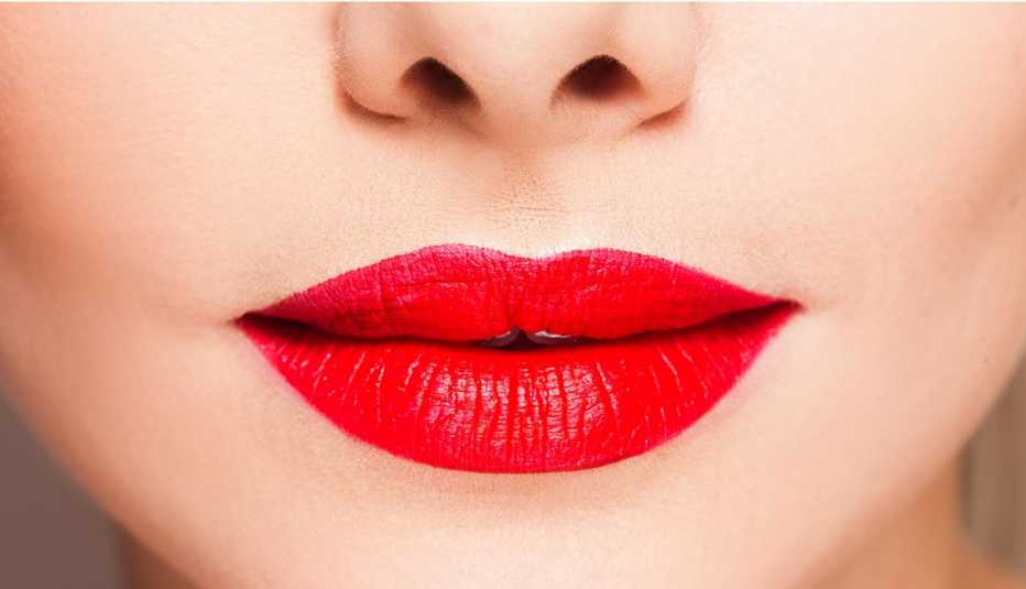 Rostro de mujer con los labios pintados de rojo