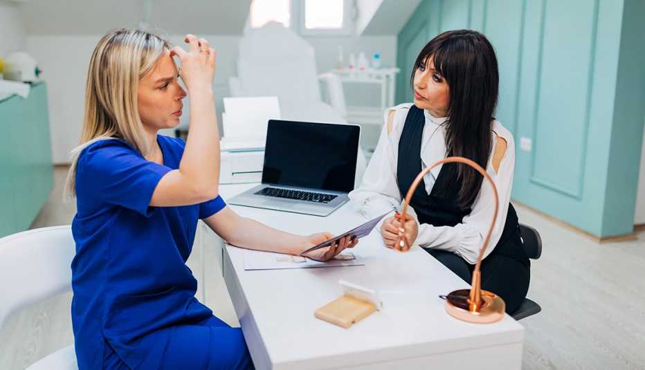 Una dermatóloga explica los tratamientos a una clienta.