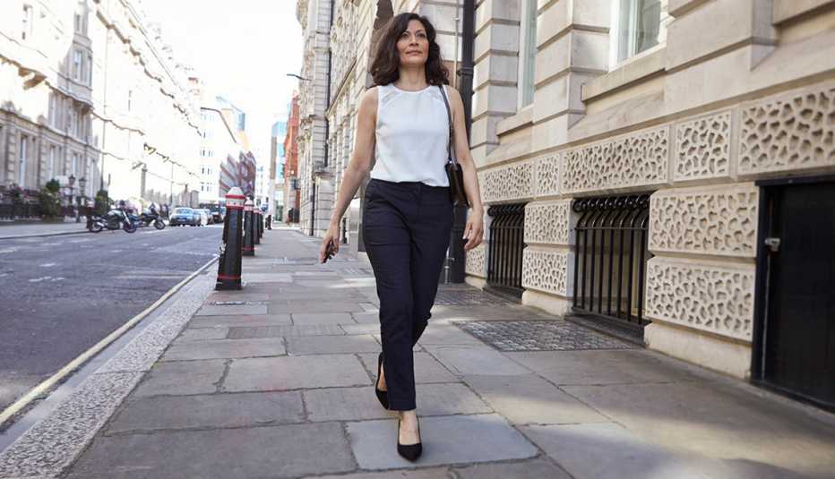 Una mujer caminando en la ciudad vistiendo pantalones.