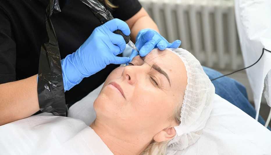 Una mujer mientras se hace microblading en sus cejas.