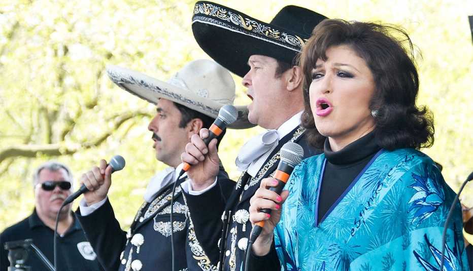 Angélica María cantando junto a un grupo de mariachi