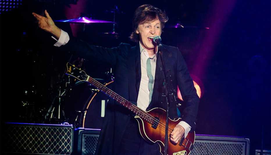 Paul McCartney cantando con una guitarra