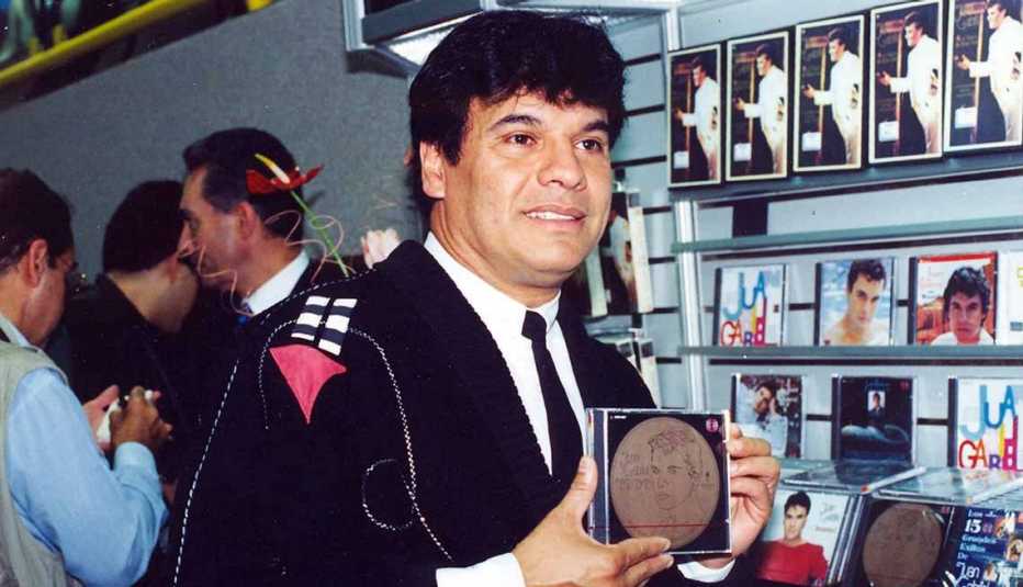 Juan Gabriel sosteniendo un CD en sus manos