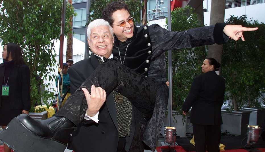 Tito Puente cargando a su hijo Tito Puente Jr.