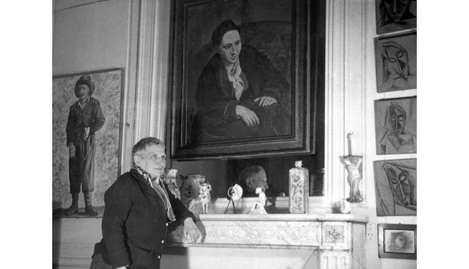 Escritora estadounidense Gertrude Stein frente a su retrato