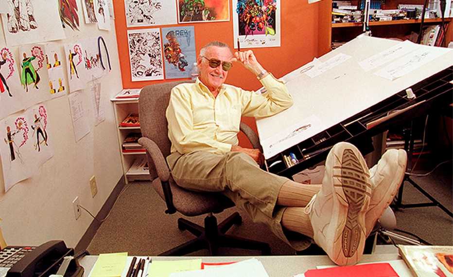 Stan Lee apoyado en su mesa de dibujo en su oficina.