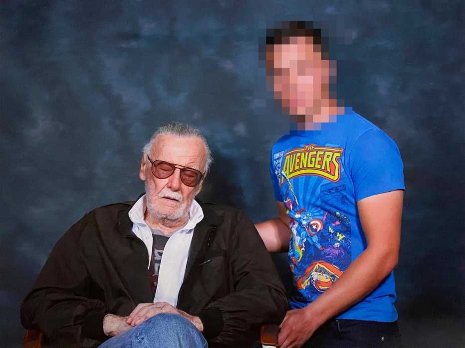 Stan Lee sentado en una silla se queda dormido junto a un fan mientras posa durante una sesión fotográfica.