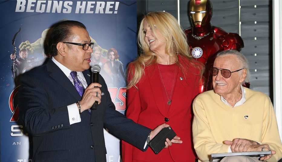 El publicista Jerry Olivarez sostiene el micrófono mientras J.C. Lee y Stan Lee miran.
