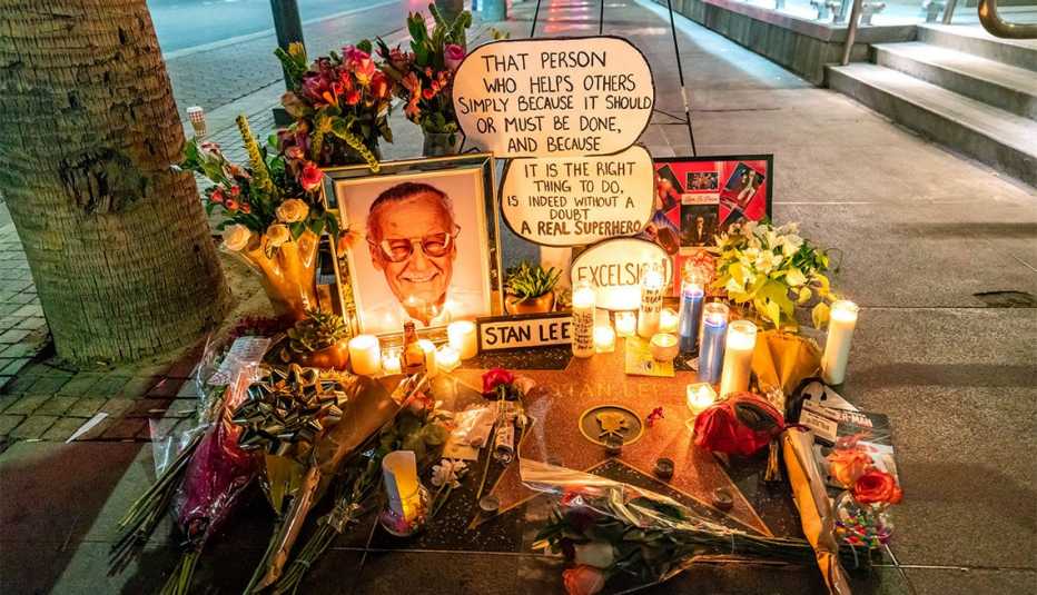 Velas, flores y la imagen de Stan Lee adornan la acera como memorial tras su muerte.