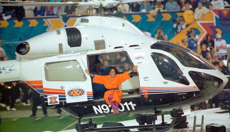 Diana Ross sentada en el borde de un helicóptero durante su actuación en el espectáculo de medio tiempo del Super Bowl XXX.