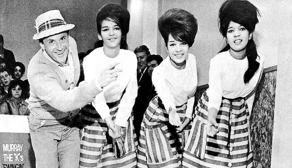 El trío vocal estadounidense The Ronettes en 1962 con el disc jockey de Nueva York Murray the K (Murray Kaufman). De izquierda a derecha: Nedra Talley, Ronnie Spector, Estelle Bennett
