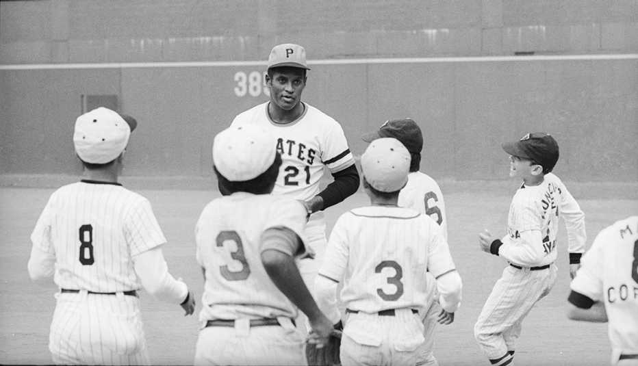 Roberto Clemente en Three Rivers Stadium en Pittsburgh con un grupo de jóvenes de Puerto Rico con uniformes de béisbol.