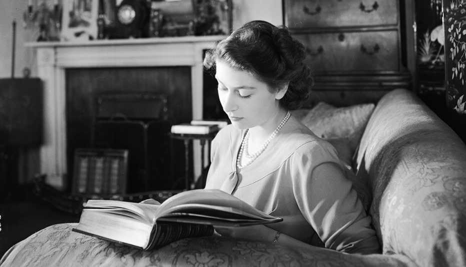 La princesa Isabel (Reina Isabel II) leyendo en su apartamento en el Palacio de Buckingham, Londres.