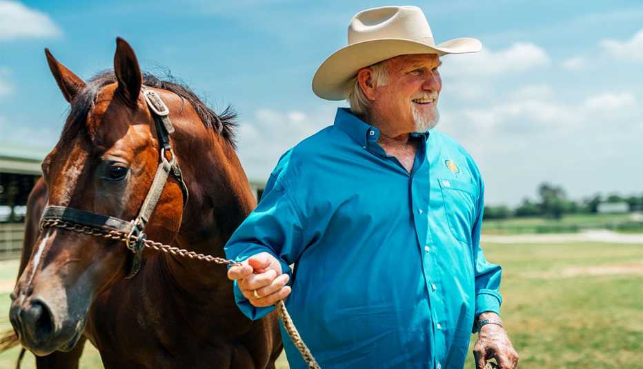 Terry Bradshaw junto a un caballo al aire libre.