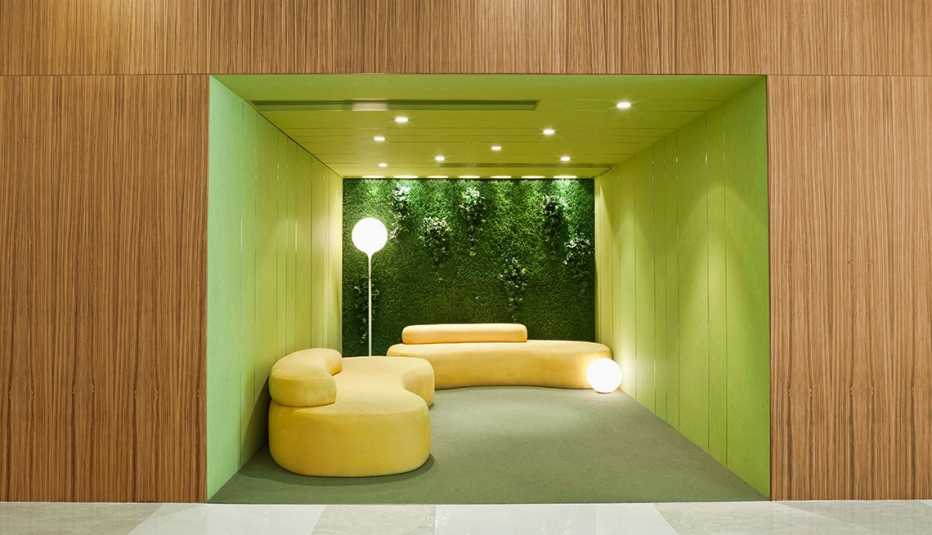 Interior con sofá moderno y una pared con jardín vertical