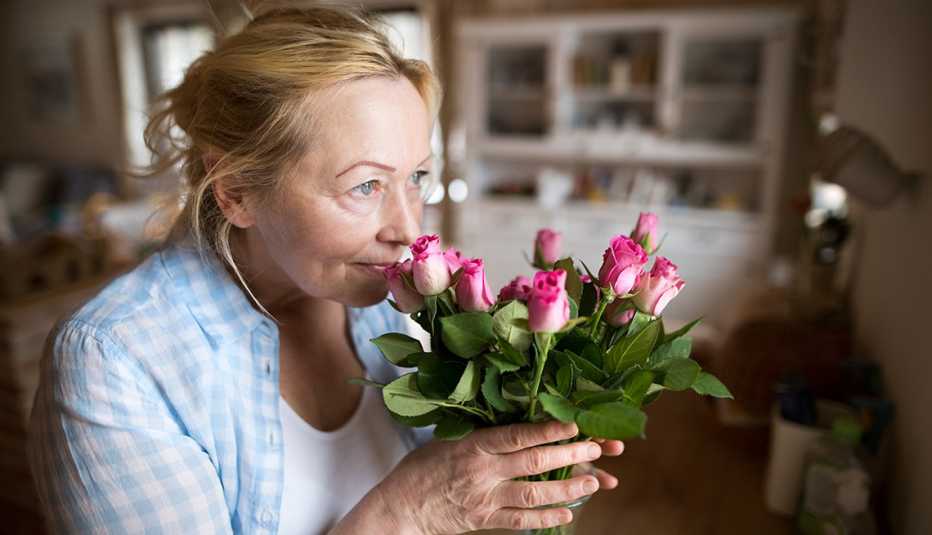 Mujer huele unas flores