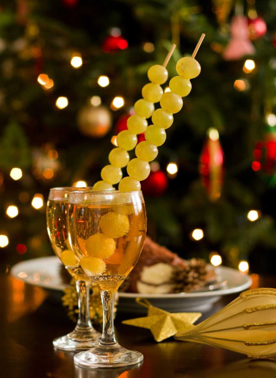Copas de champaña con uvas verdes y decoración para la celebración de fin de año.
