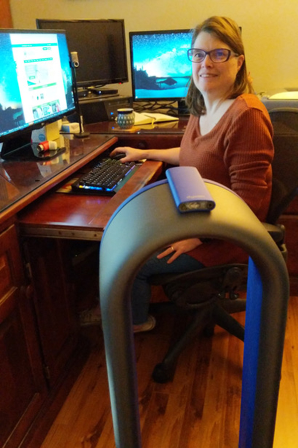 Una mujer sentada en un escritorio junto a un filtro de aire
