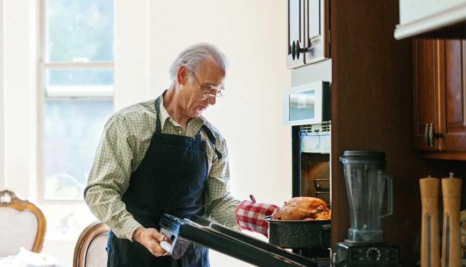 Hombre mayor cocinando la cena para el Día de Acción de Gracias
