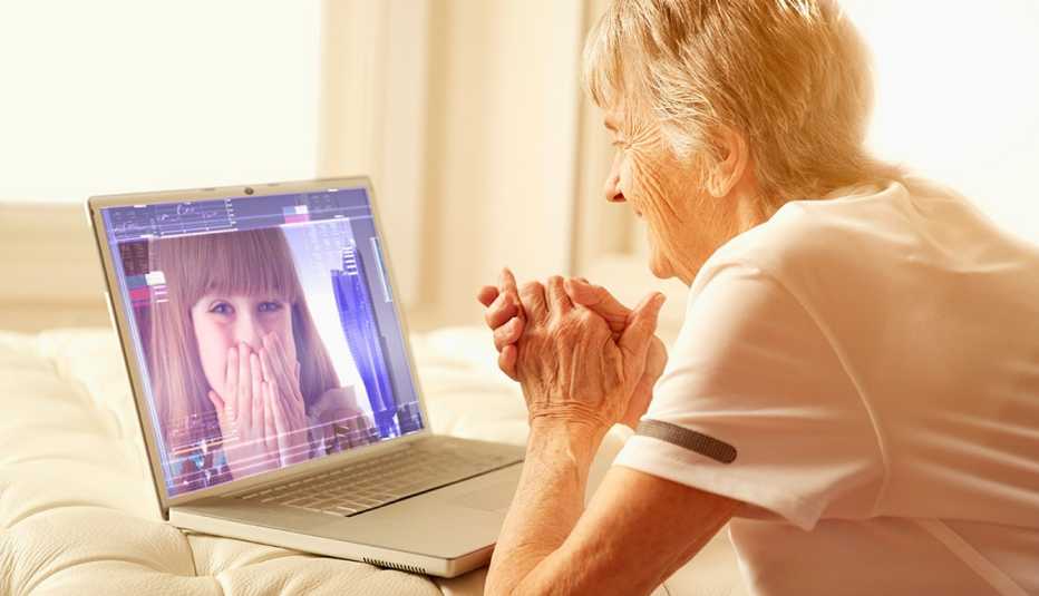 Una mujer mayor conversa con un familiar a través de una videollamada