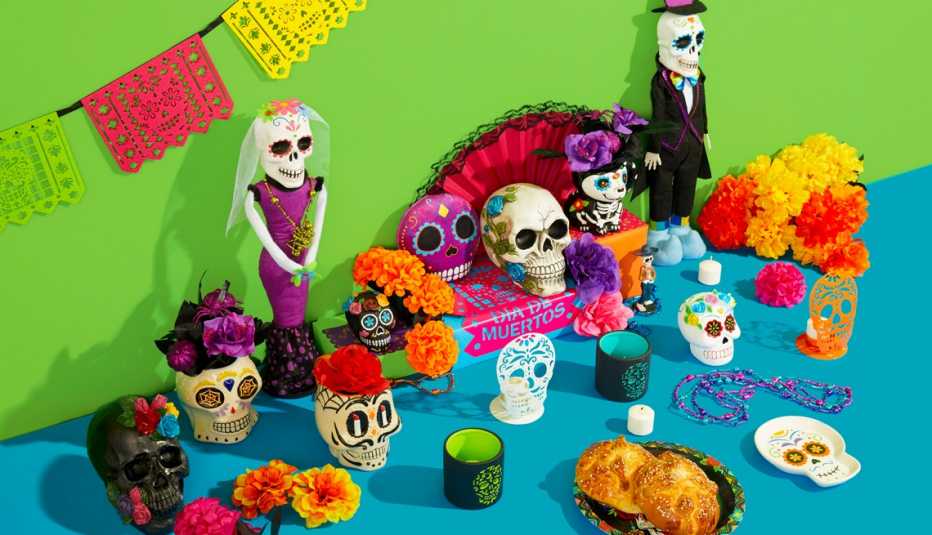 Mesa decorada para el día de los muertos con esqueletos y ofrendas de comida