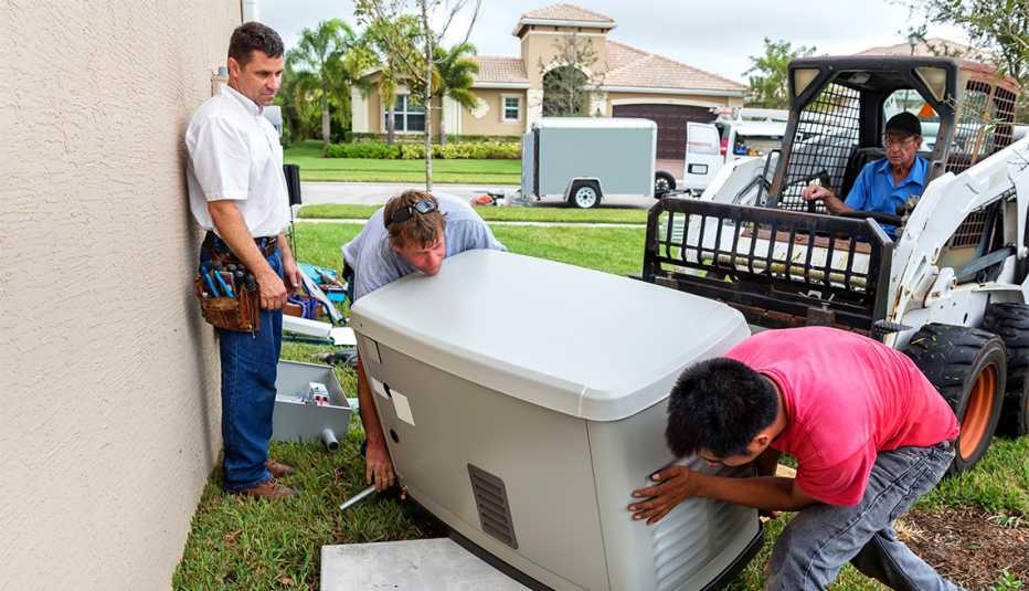 Grupo de hombres instalan un generador eléctrico de emergencia para una casa
