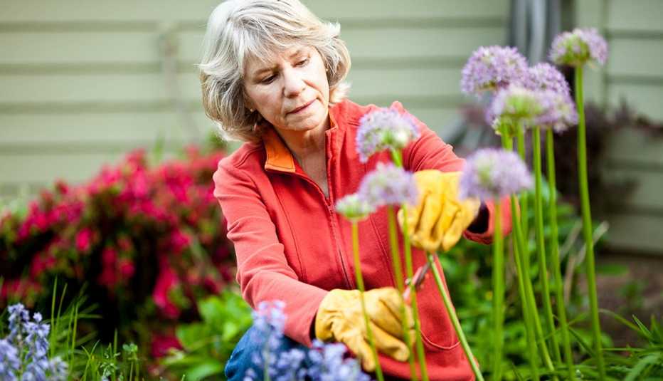 Mujer en el jardín cortando flores