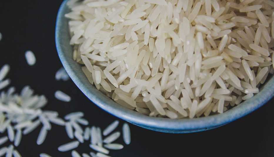 un plato de arroz blanco sobre un fondo negro