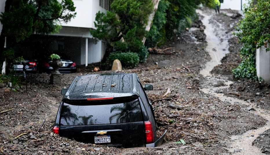 Un SUV negro atrapado en el barro después de fuertes lluvias en el sur de California