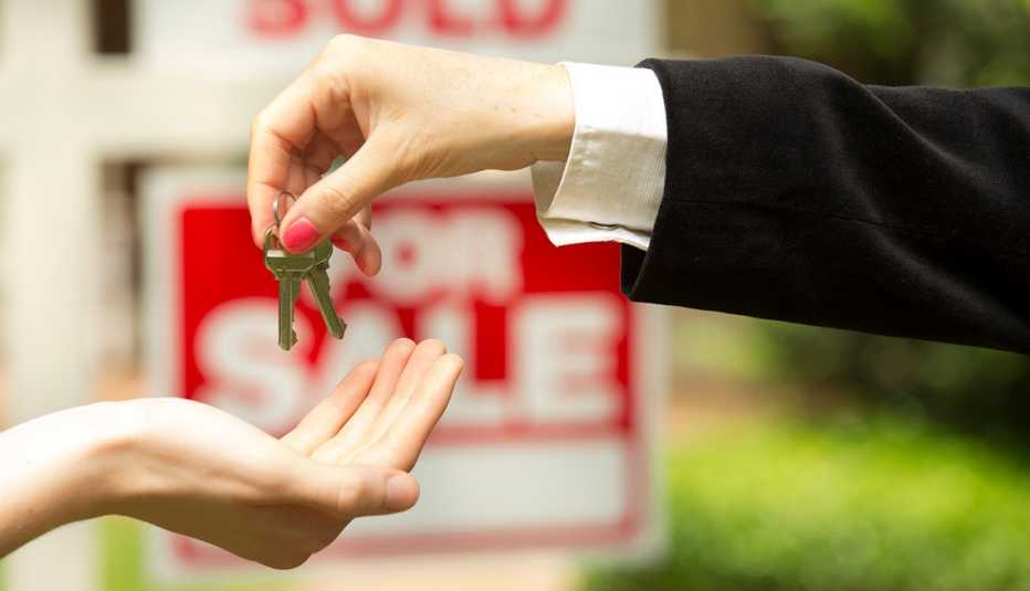 Una persona entrega las llaves de una casa que se acaba de vender