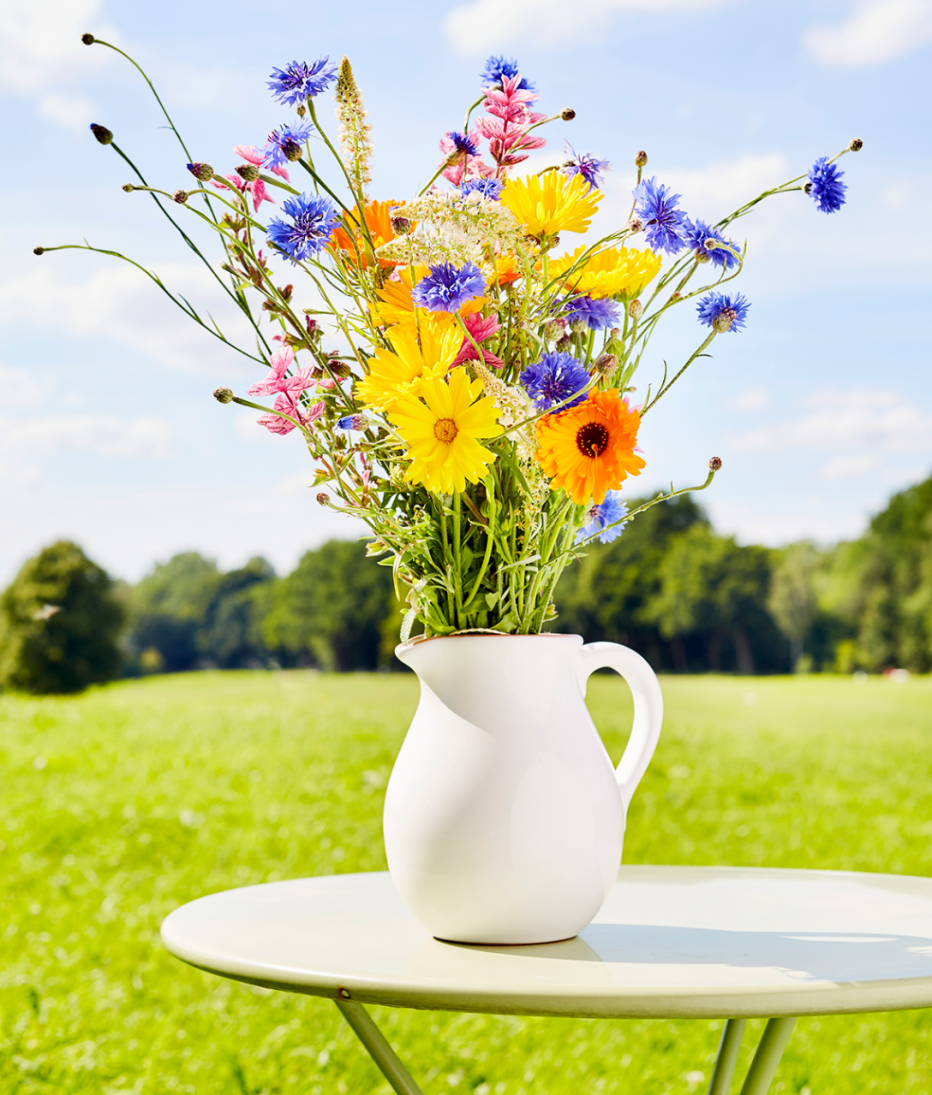 Un jarrón de flores en una mesa al aire libre
