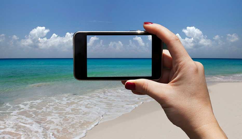 Persona toma una foto con su teléfono inteligente en la playa