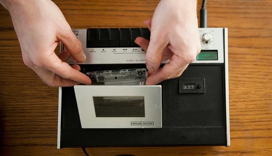 Manos insertando una cinta en una grabadora