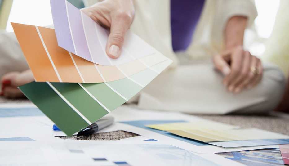 Mujer sostiene paletas de colores para pintura