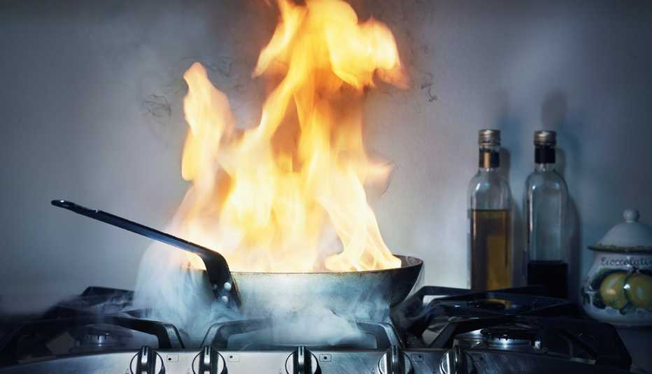 Fuego en una sartén en la cocina
