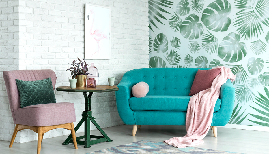 Sala de estar con papel tapiz y decorada en tonos verdes y rosa